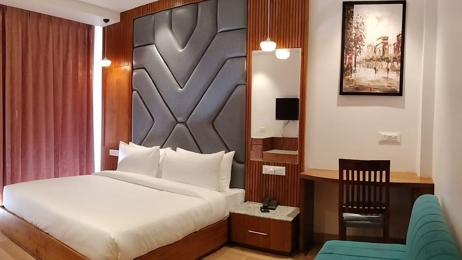 A sofa in front of a bed  in Premium Room With Balcony at DLS Ark Holiday Inn, Banikhet.