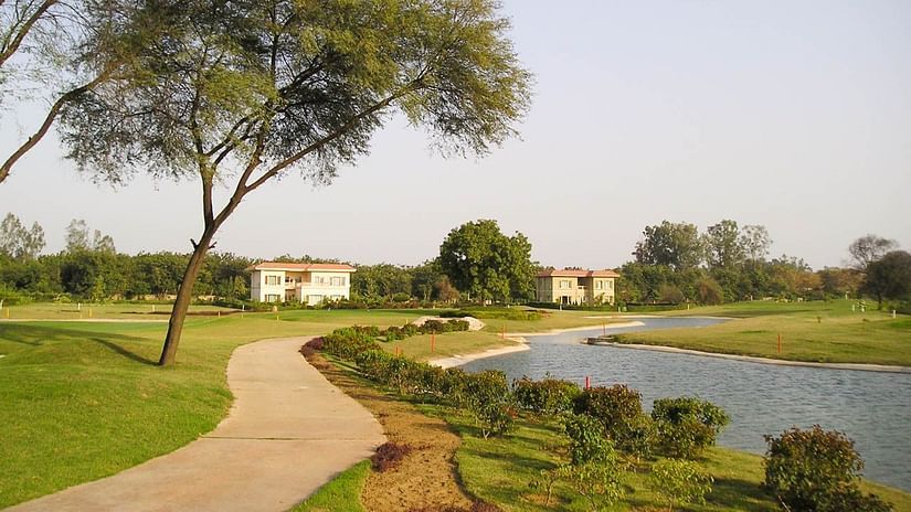 a waterbody next to the garden and trees in view as well at Karma Lakelands.