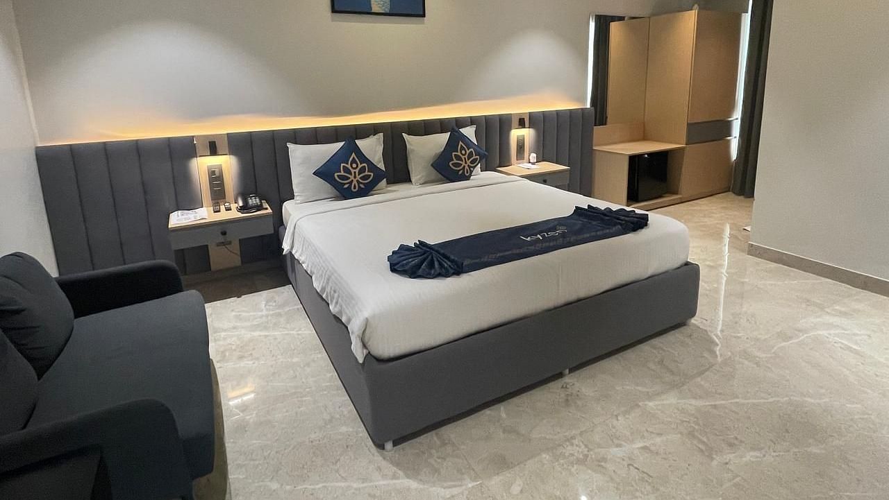 Suite with a neatly arranged king size bed and side tables at Hotel Kyzen HiTech City – Your Zenly Stay