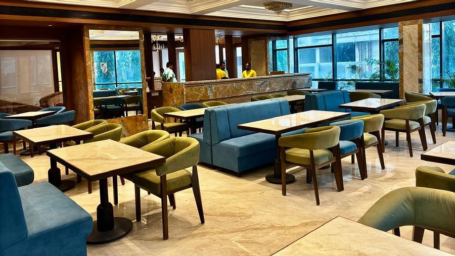 Dining space featuring a fancy ceiling and seating arrangements at Hotel Mumbai House, Vashi.