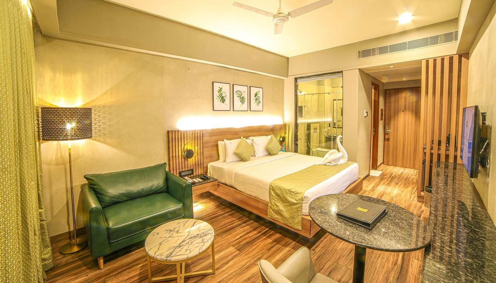 A double bed and a sofa in the Premium Balcony Room at Grand Palace, Yercaud