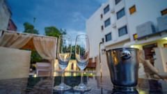 Glasses and ice bucket placed on a table in poolside setting at Golden Tulip, Udaipur.