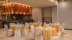 Dining area with banquet seating and bar counter at Golden Tulip, Udaipur.