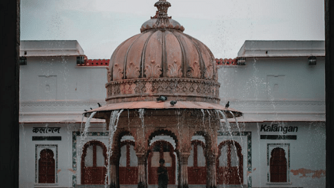 An architectural structure with a dome, framed by an arch.