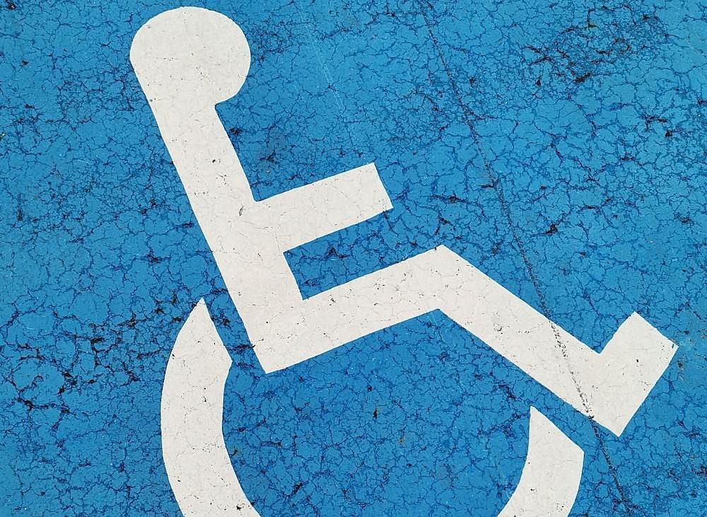 A parking space with a wheelchair symbol, indicating accessibility for people with disabilities.
