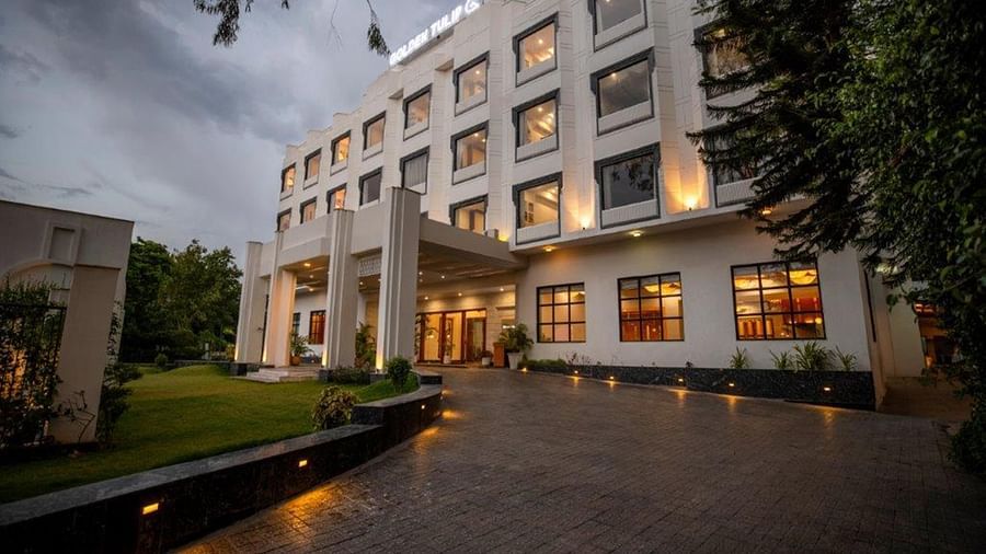 The entrance of Golden Tulip, Udaipur with trees and evening lighting.