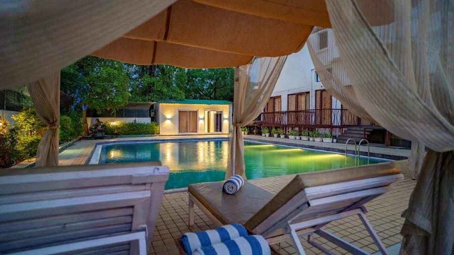 Private cabana seating with curtains beside the swimming pool at Golden Tulip, Udaipur.
