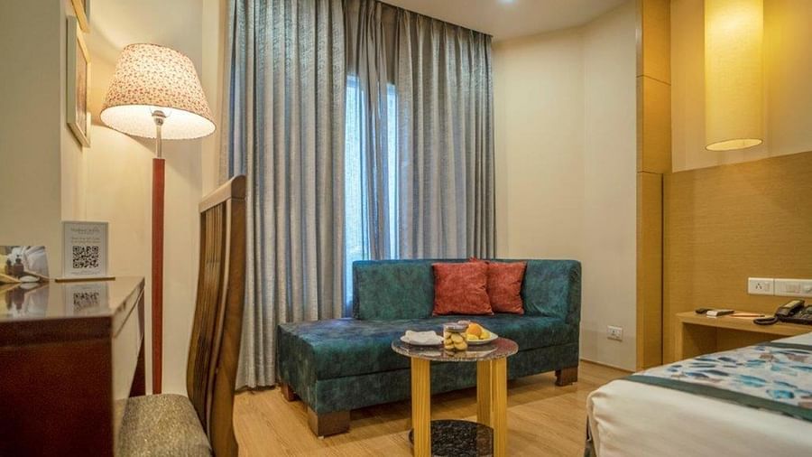 Premium double pool room with a couch, curtain, and a single bed at Golden Tulip, Udaipur.