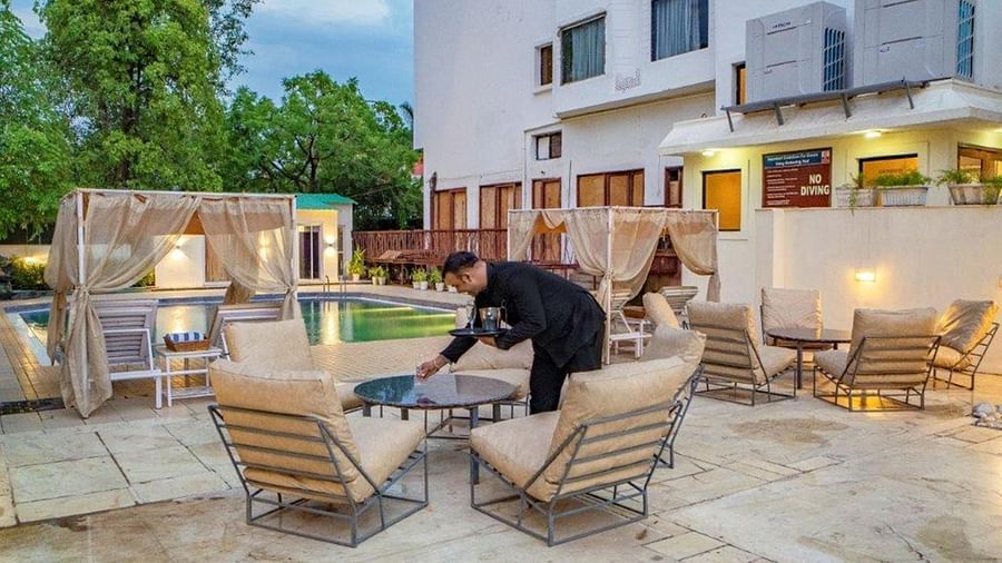 Hotel staff serving drinks in the poolside seating area at Golden Tulip, Udaipur.