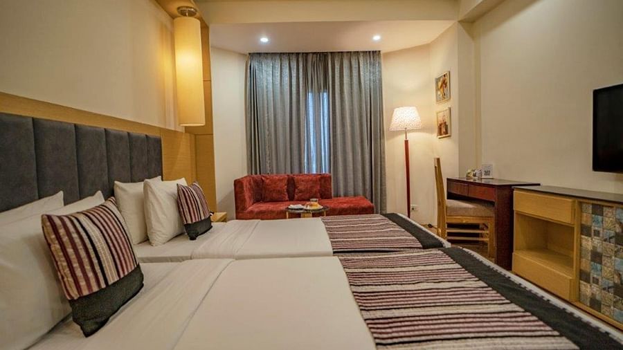 Superior Room with twin beds, striped bedding, and window curtains at Golden Tulip, Udaipur.