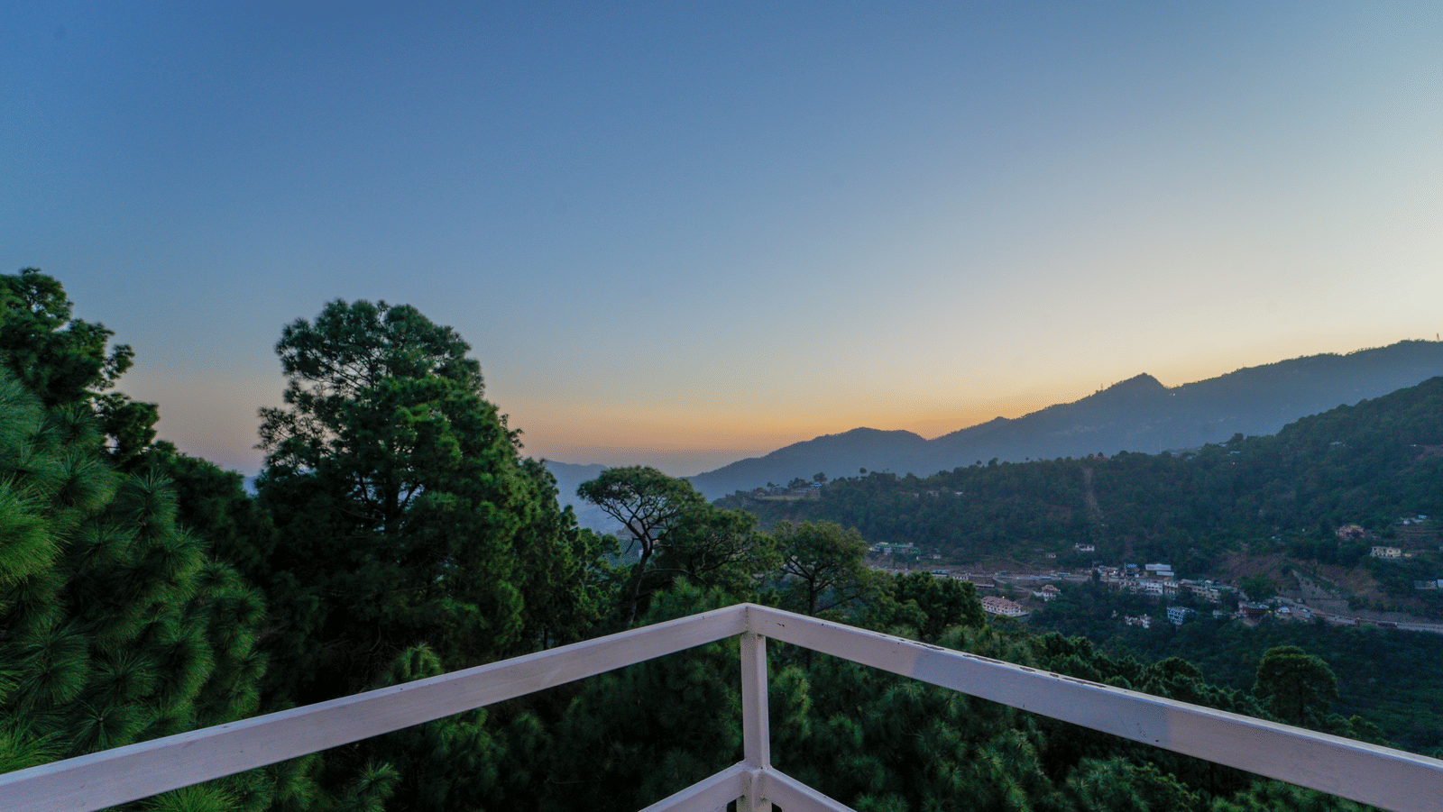 An overview of the open terrace at our Nature Resort Kasauli - DLS Whispering Winds, Kasauli, showcasing lush greenery around.