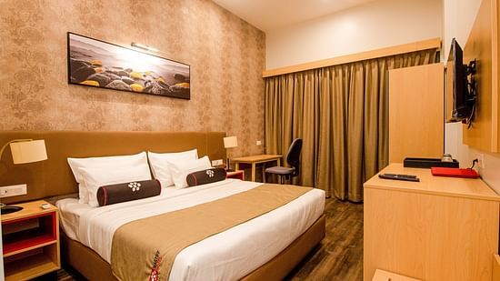 closer view of premier room with king size bed in a room with beautiful wooden furniture - Mastiff Hotel, Ankleshwar