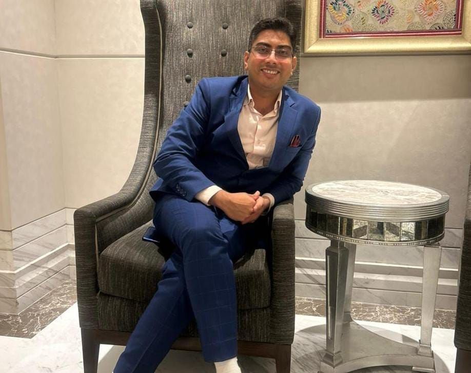 Avinash Singh sitting on a sofa and posing 