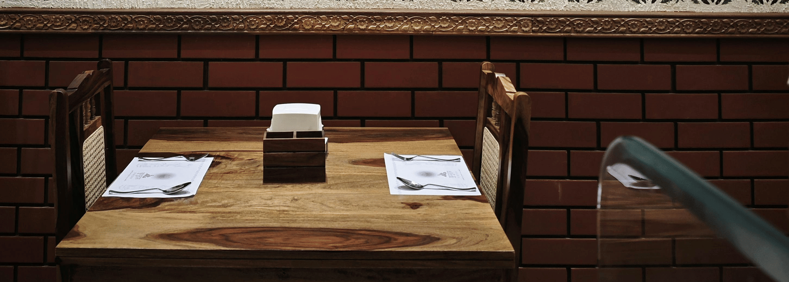 Close-up of a framed artwork hanging above a wooden dining area.