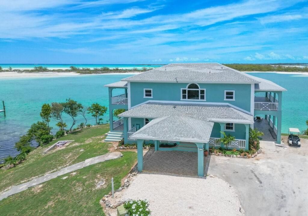 An aerial view of a villa with a backdrop of the ocean along with a bright blue sky in the background at the Ole Ike Bay.