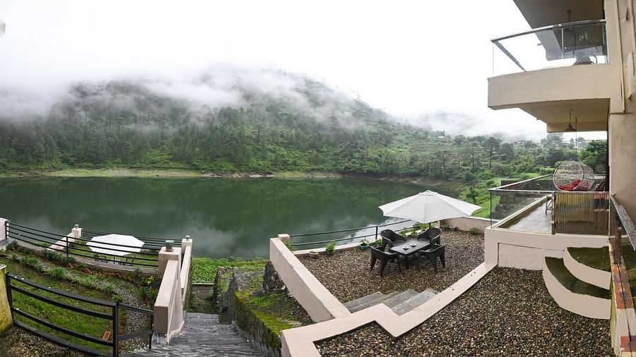 View from the hotel facing a serene green lake and forested hills.