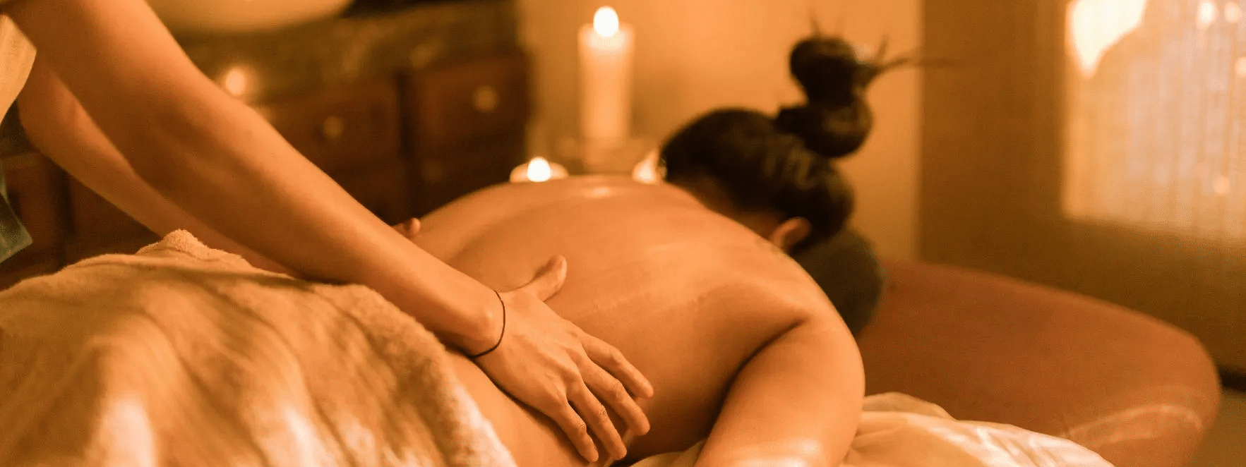 Person receiving a back massage in a spa room at Karma Chalets.
