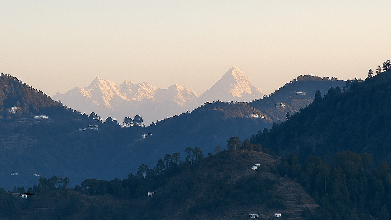 The majestic snow capped mountain at the far with small settlements scattered all around the mountain range.
