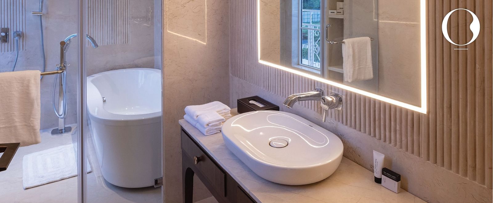 Close up shot of a wash basin along with a bathtub in the middle at Miros Hotels.