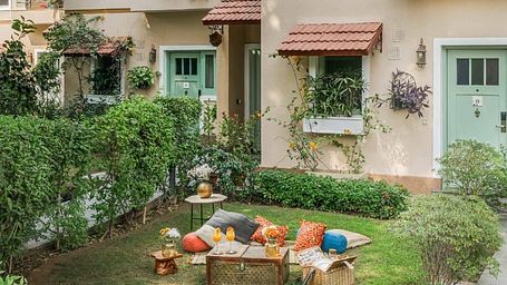 Outdoor garden area at Karma Chalets with a picnic setting and small plants in front of a cottage entrance.