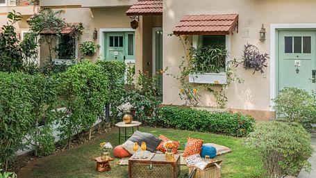 Outdoor garden area at Karma Chalets with a picnic setting and small plants in front of a cottage entrance.