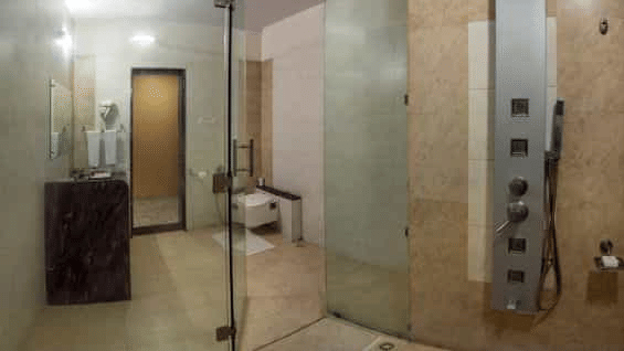 A modern shower cubicle with a rainfall showerhead and multiple body jets - Lion Lords Inn Rajula