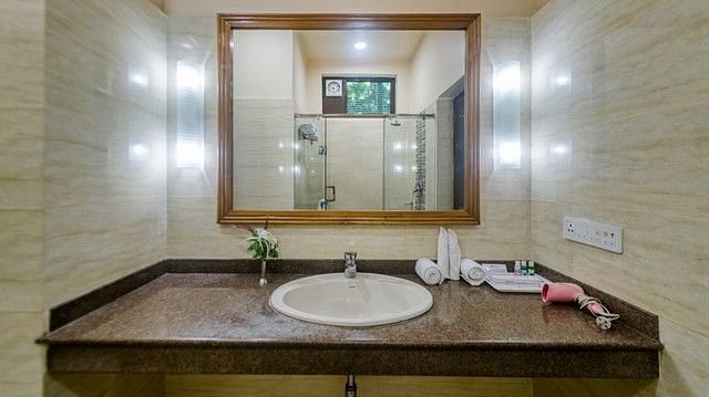 Modern resort bathroom with stylish vanity and ample lighting fixtures.