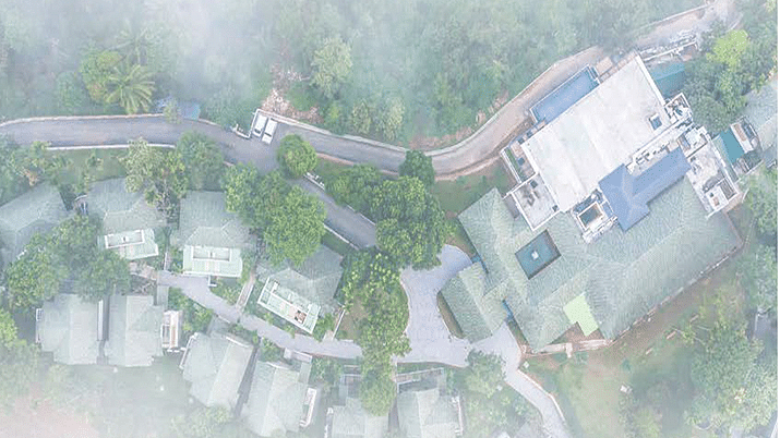 Aerial view of a resort surrounded by greenery, showcasing its layout with buildings and pathways.