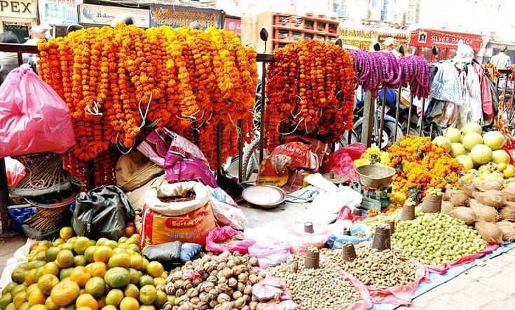 A small roadside shop selling flower garlands, fruits and more
