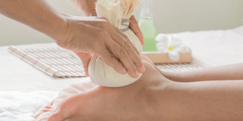 A person receiving poultice massage on their foot and ankle
