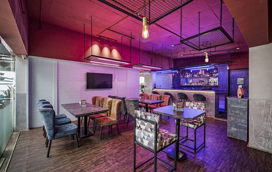 An image of the Bryants Lounge with seating arrangement, and decorative lighting hanging from the ceiling - GReaT Trails Kodaikanal By GRT Hotels