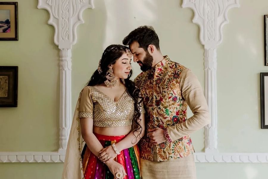 A couple stands together, dressed in colourful traditional attire - Umaid Palace - Best Luxury Heritage Resort Near Jaipur. 