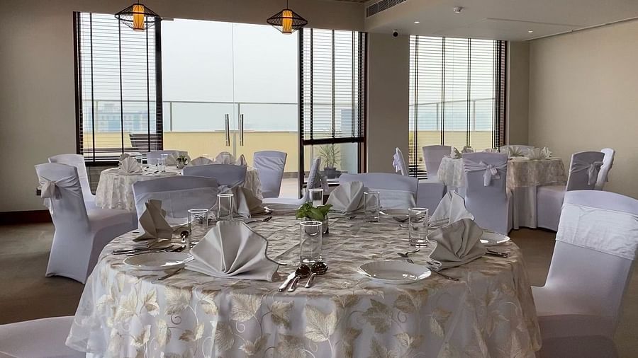 An image of a banquet hall with its seating arrangement and subtle decoration with lighting - Hideaway banquets & Lawns, Greater Noida