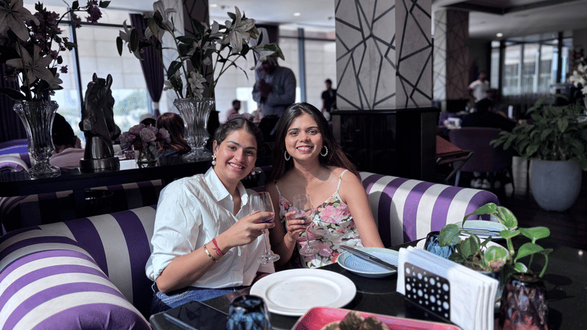 Two people sitting on a couch with a party setup at Karma Lakelands