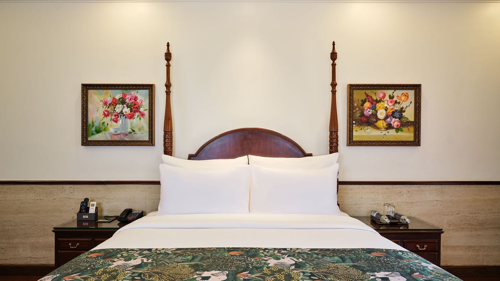 Deluxe bedroom with a comfortable twin bed, bedside tables on both side and picture frames on the wall.