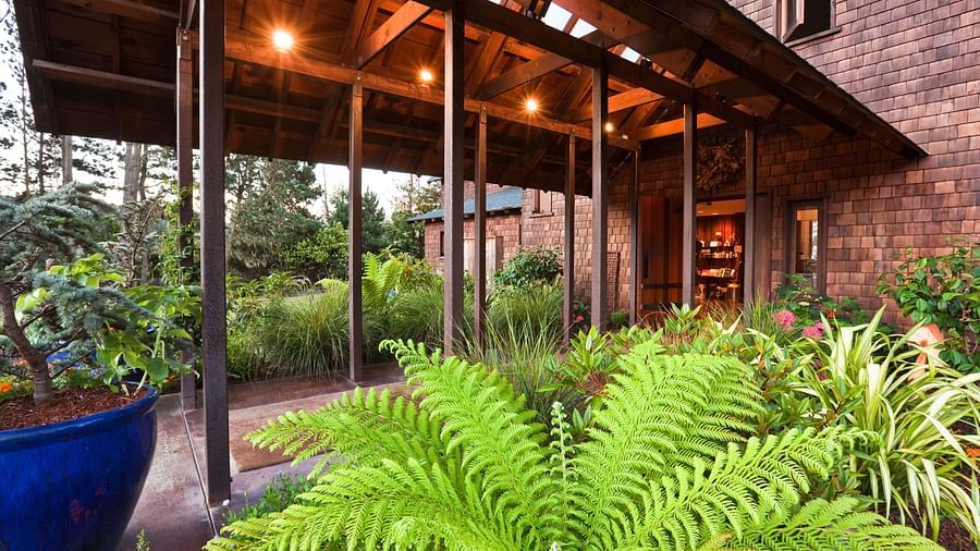 The warmly lit Entrance featuring wooden ascents and lush greenery - Brewery Gulch Inn & Spa