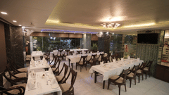 Indian Cuisine Restaurant - Dawat-e-Zaika featuring tables and chairs arranged under warm lighting at Hotel Atulyaa Taj, Agra