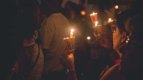 People attending mass with candles in hands