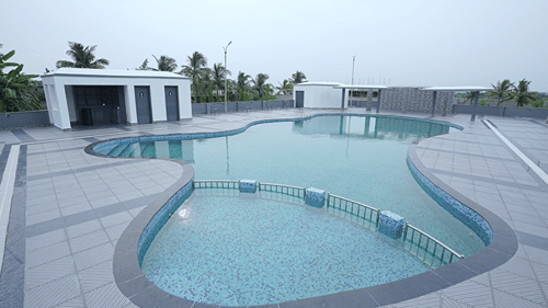 Symmetrical view of the rooftop pool at Pride Elite Mandarmani with its railed shallow end in the foreground and washroom block on the left.