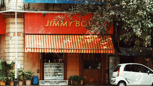 Exterior of Jimmy Boy restaurant in Mumbai with its bright red awning.