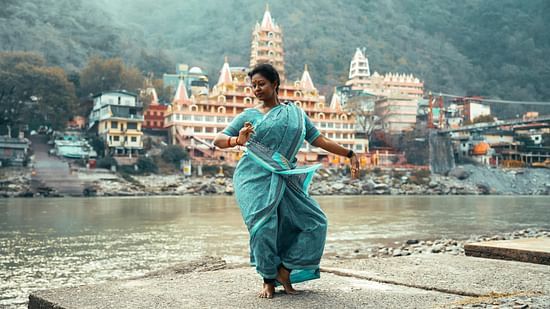 A woman dancing on the banks of the River in the day time