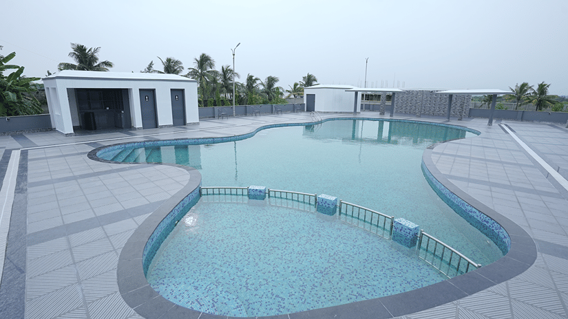 Symmetrical view of the rooftop pool at Pride Elite Mandarmani with its railed shallow end in the foreground and washroom block on the left.
