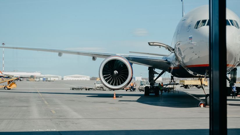An aeroplane parked in an airport as seen from inside the terminal