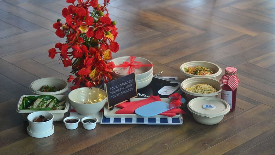 food parcel boxes kept on a wooden surface with some flowers - polo floatel kolkata