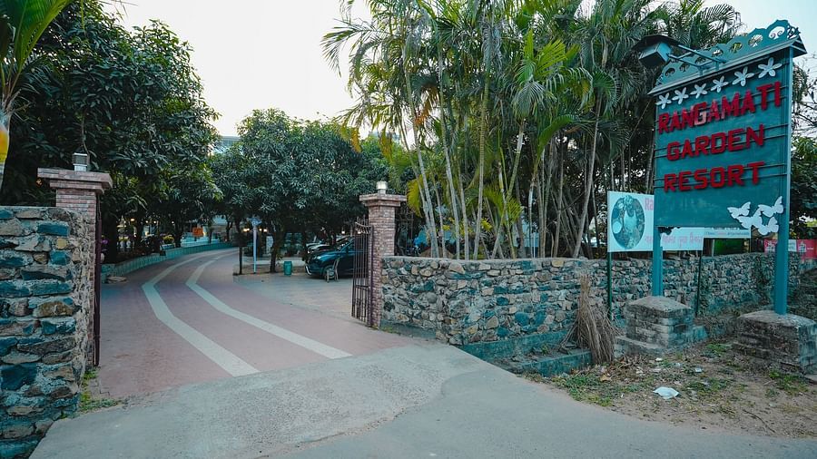 An image of a pathway filled with trees on either side which is leading to Rangamati Garden Resort