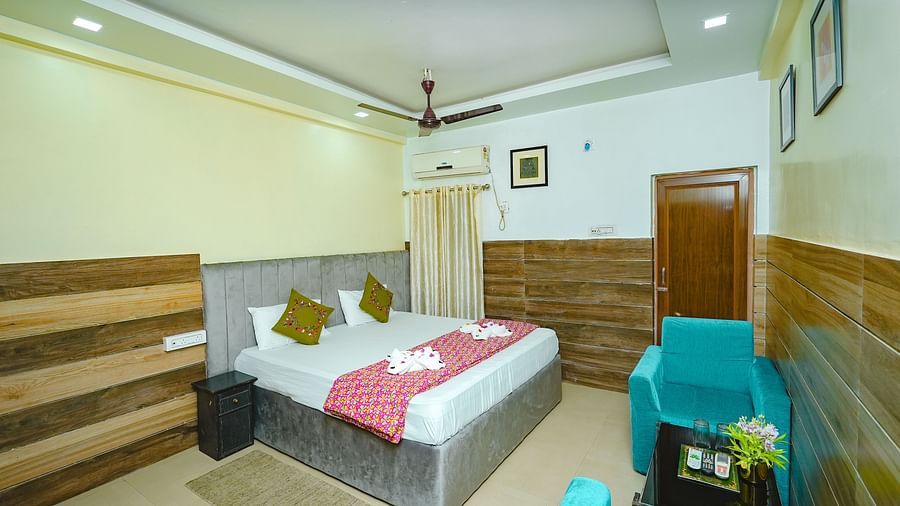 An image of Standard Double Bed Room featuring a bed, a seating area with sofa and centre table, and a bedside table at Rangamati Garden Resort