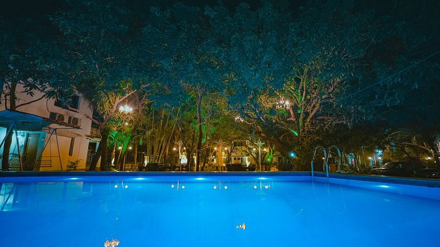 An image of a Swiming Pool with having some trees around and a building at Rangamati Garden Resort