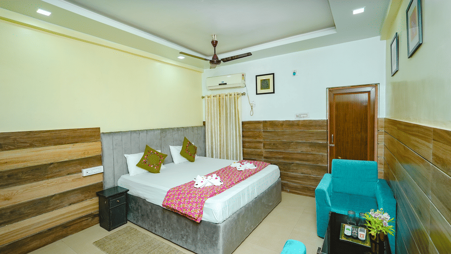 The Standard Double Bed Room featuring a bed, a seating area with sofa and centre table, and a bedside table at Rangamati Garden Resort