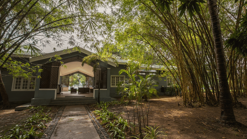 The Waterfront Verandah at The Serai Kabini is accessed by a pathway leading through the grounds and surrounding trees.