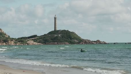 The iconic Ke Ga Lighthouse on a small island near the ocean, viewed from a distance at WoCAL Retreat Ke Ga.